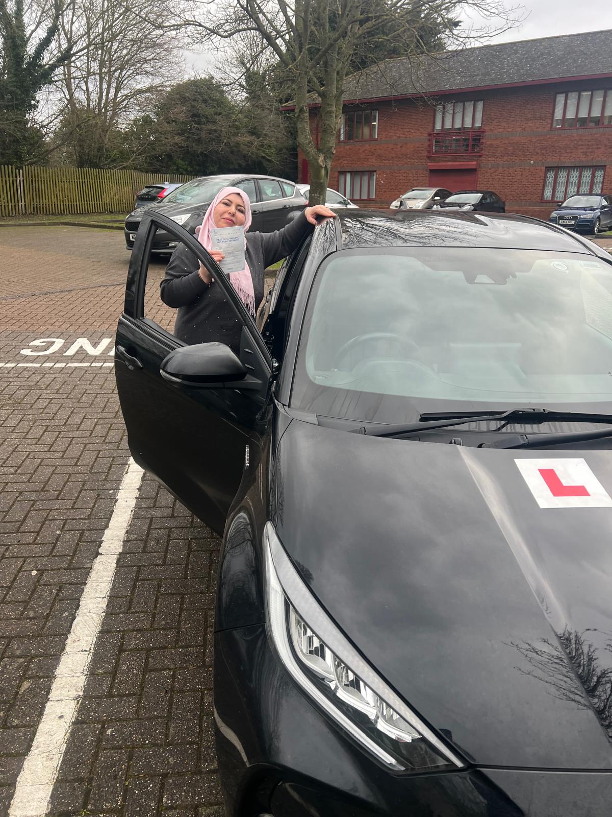 Student holding driving test pass certificate