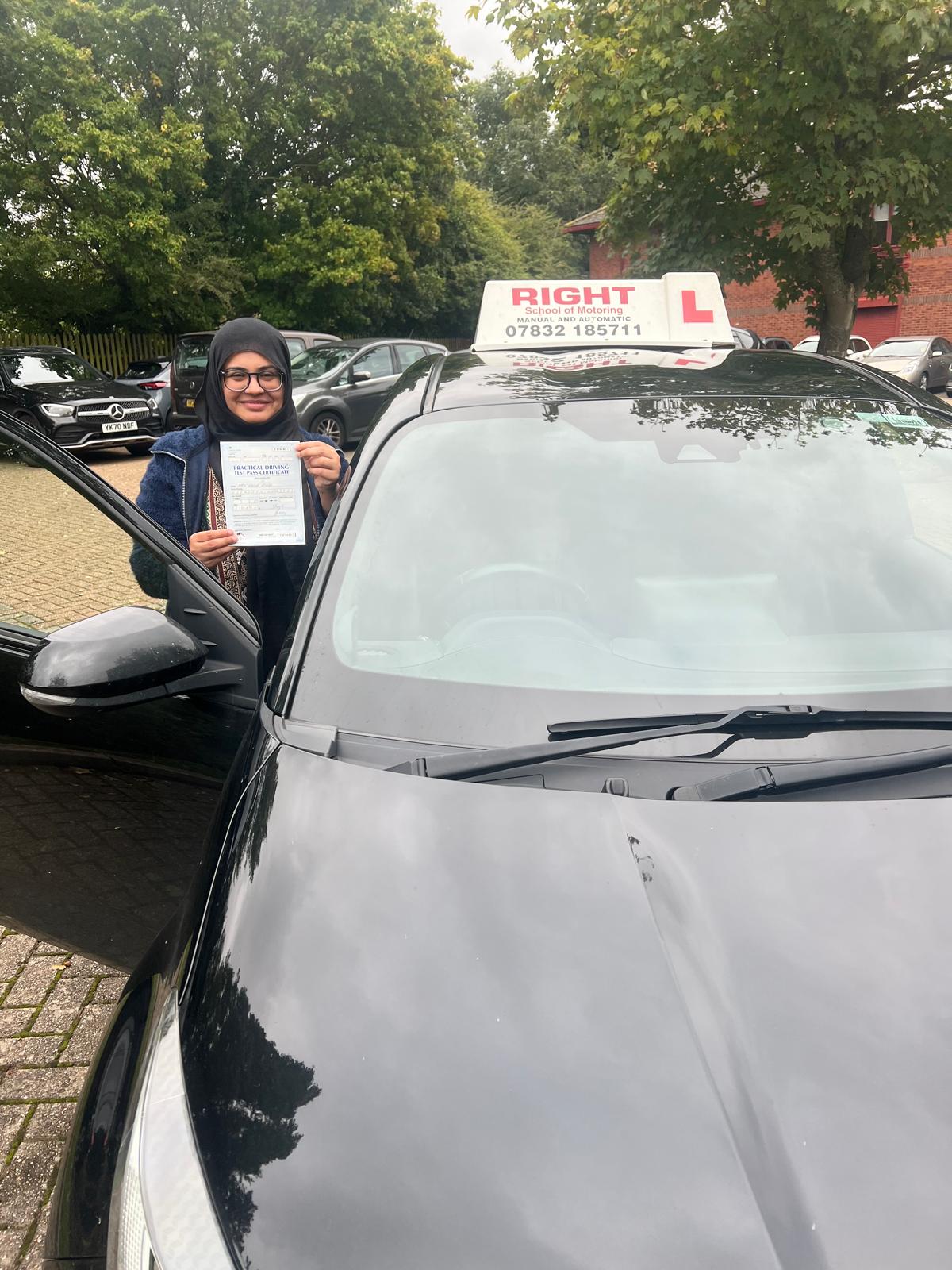 Student with pass certificate standing by instructor vehicle